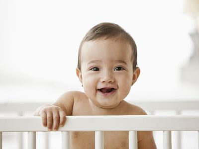Smiling baby standing in crib