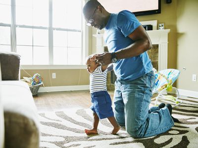 Man helping his baby learn to walk