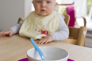 Baby girl staring at empty bowl and spoon